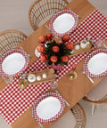 Kickin Vibes Red Gingham Oval Paper Plates 40 Count 10 X 12 Inch Heavy Duty Disposable setting on a dining table with florals.