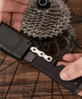 User operating Two In One Chain Whip And Lockring Tool For Cassettes The Ultimate Bike Maintenance Kit on bicycle wheel cassette