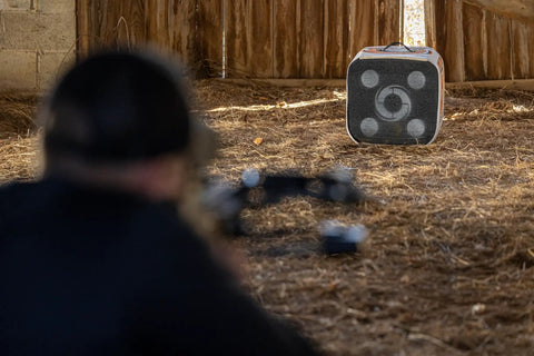 GenZ XL 20 Inch Youth Archery Target For Beginners Up To 40 Lb Bows in a barn setting with an archer aiming at the target
