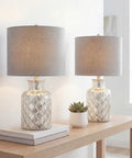 Alvord Mercury Silver Quatrefoil Glass Table Lamps Set of 2 with Grey Linen Drum Shades on a wooden console.