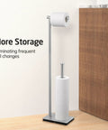 Freestanding Toilet Paper Holder Stand With Reserve Storage In Rustproof Stainless Steel Brushed Finish beside wooden cabinet.