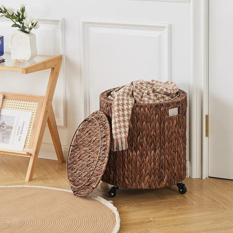 Round Water Hyacinth Storage Basket With Lid And Wheels Boho Chic Natural Rattan Bin shown as ottoman in living room