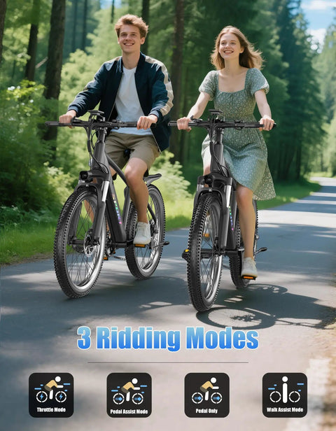 Two adults riding Beast Mode 1500W Peak Electric Mountain Bikes with 26 inch wheels on a forest path