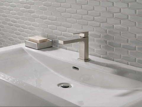 Xander Single Handle Bathroom Faucet In Brushed Nickel, Fits 1 Or 3 Hole Install, on modern white sink with hexagonal tiles.