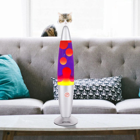 Dope Motion Lava Lamp 13.5 Inch With Silver Base, Orange Wax In Purple Liquid, on a living room table, with a pet in the background