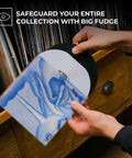 Person placing a vinyl record into a clear 50 pack 7 inch vinyl record outer sleeve 3 mil thick wrinkle free polypropylene ultra transparent cover.
