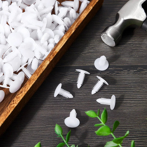 Top Notch Heavy Duty Christmas Fasteners And Vapor Barrier Clips In 1 Inch White scattered nylon clips and a hammer on wood.