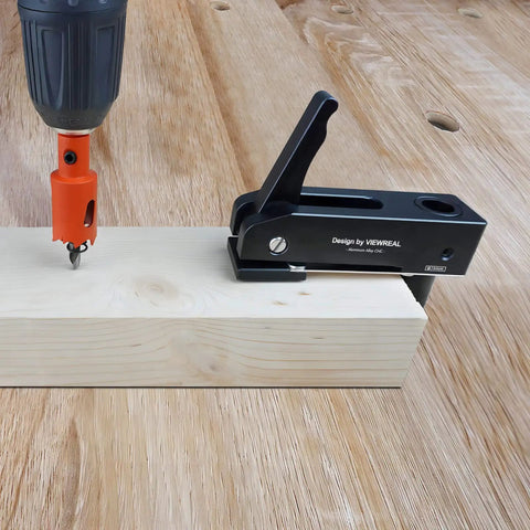 Two Pack Three Quarter Inch Aluminum Alloy Bench Dog Clamps For Woodworking With No Sweat One Hand Quick Release Lever and Rock Solid Hold Down Grip For Hassle Free Benchtop Workholding on wooden surface with drill.