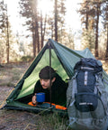 Person using Forest Scout Backpack Tent for Quick Camp Setup Lightweight Frame Shelter With 1000mm PU Coated Polyester