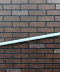 No Sweat 10 Ft Wall Mounted Aluminum Handrail In Gloss White With Returns secured to a brick wall, providing support for steps.