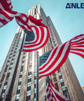 American flags waving on flagpoles in front of a skyscraper, showcasing urban architecture and patriotism.