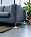Four Pack Heavy Duty Adjustable Leveling Feet With Anti Vibration Pads under a sofa on a polished floor
