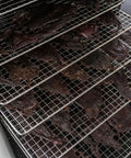 Heavy Duty Food Dehydrator With Digital Thermostat And Set It Forget It Timer Six Grease Resistant Stainless Steel Trays holding jerky.