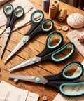 Assorted Size Scissors 4 Pieces Set With Heavy Duty Stainless Steel Blades Ambidextrous Comfort Ergonomic Rubber Grip 8.5 Inch 7.5 Inch 6.5 Inch And 5.5 Inch For Home Office School Crafts And Multi Use Cutting. Four scissors on a sewing table