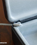 Close-up of tether cable and hinge inside Compact Portable Mini Safe With Key Lock For Office Or Dorm Stash Cash Keys Passports And Small Valuables Perfect For Campus Coffee Shops And Desk Security.