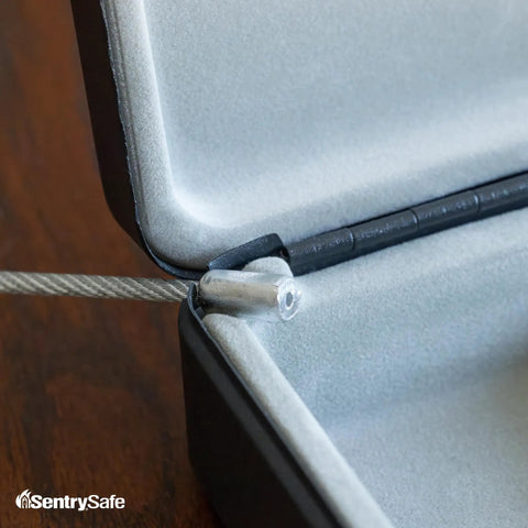 Close-up of tether cable and hinge inside Compact Portable Mini Safe With Key Lock For Office Or Dorm Stash Cash Keys Passports And Small Valuables Perfect For Campus Coffee Shops And Desk Security.