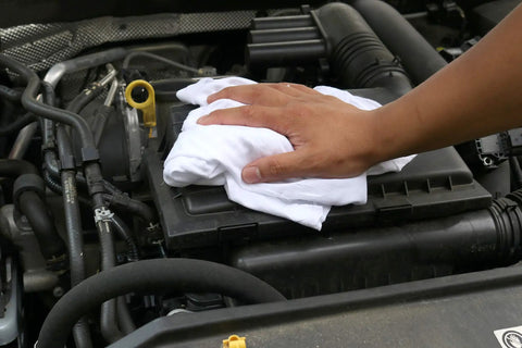 Hand using Bulk 10 Lb White Cotton T Shirt Rags for painting stains grease cleaning in the shop or auto use on car engine