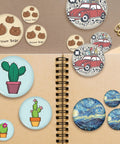 3 Inch Button Maker Supplies Kit 100 Sets 400 Pieces With 75mm 2.95 Inch Button Parts Metal Blank Badges And Blank Paper For DIY Button Making Machines Pin Makers, assorted finished badges on notebook
