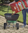 Person pouring All In One Lawn Insect Killer into a lawn spreader, effective on ants, fleas, ticks, and more for up to 3 months.