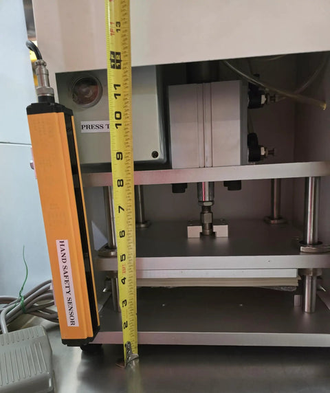 Workhorse Benchtop Pneumatic Press With Foot Pedal For Hands Free Operation, Dual Safety Light Curtains, And Adjustable Dwell Timer For Blister Packaging, Stamping, Riveting, And Component Assembly close-up with safety sensor and tape measure