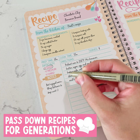 Person writing in a chocolate chip banana bread recipe on a spiral-bound blank recipe book for writing your own dishes.