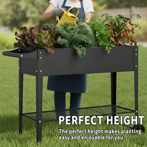 Person tending to vegetables in a 32 Inch Tall Raised Garden Bed with Wheel Planter Box For Backyard And Balcony Easy Move With Ergonomic Handle Dual Layer Drainage To Prevent Waterlogging Space Saving Fits Narrow 29.5 Inch Corners 400lb Capacity, shown outdoors on grass.