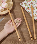Three Six Top Shelf Wooden Dowel Rods With Dual Center Holes 11 8 Inch Solid Hardwood Sticks displayed with a coin for size reference.