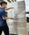 Person using Two Pack Clear Stretch Wrap Film 18 Inch By 1000 Feet 80 Gauge Industrial Strength With Plastic Handle on a pallet