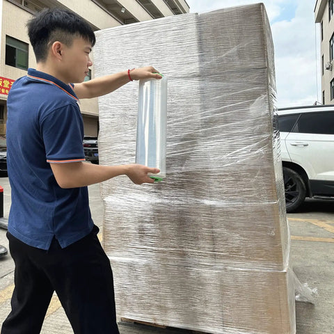 Person using Two Pack Clear Stretch Wrap Film 18 Inch By 1000 Feet 80 Gauge Industrial Strength With Plastic Handle on a pallet