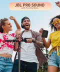 Three friends enjoying music outside with a red Go 4 Portable Bluetooth Speaker With IP67 Waterproof And Dustproof Build in hand.