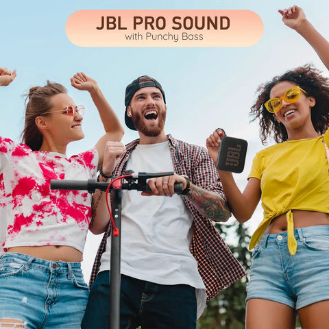 Three friends enjoying music outside with a red Go 4 Portable Bluetooth Speaker With IP67 Waterproof And Dustproof Build in hand.