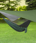 Waterproof Camping Tarp Rain Fly With UV Block Sunshade Canopy set up over hammock outdoors, includes guy lines and stakes.