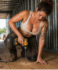 Woman installing wood flooring in a trailer using a drill, demonstrating practical use of Ride Tough 5/16-18 By 2-1/2 Inch Trailer Deck Screws.