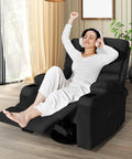 Person relaxing in a Rocking Recliner Chair With Massage And Heat, 360 Degree Swivel Faux Leather Lounge Chair in a living room.