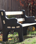 DIY Bench Ends Kit For Outdoor And Patio Benches, installed with 2x4s, black finish, in garden setting, autumn leaves around