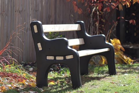 DIY Bench Ends Kit For Outdoor And Patio Benches, installed with 2x4s, black finish, in garden setting, autumn leaves around