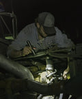 Mechanic uses Stainless Steel LED Flashlight With 171 Lumen Output Pure Beam Focusing Optic under car hood in dim light