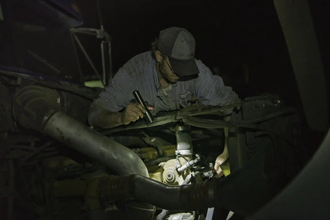 Mechanic uses Stainless Steel LED Flashlight With 171 Lumen Output Pure Beam Focusing Optic under car hood in dim light
