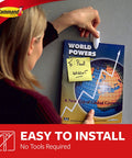 Person using Medium White Spring Clip With Three Strips For Damage Free Hanging to display magazine on wall.