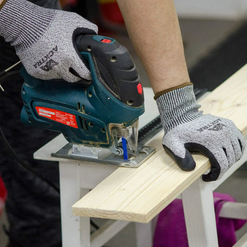Person using a jigsaw while wearing Level 5 Cut Resistant Construction Work Gloves With Foam Nitrile Coating For A Grip Like A Pro And Tactile Feel, High Tear Strength, EN 388, PPE Regulation 2016 425 Compliant, 12 Pairs, Unisex Large