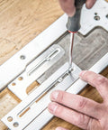 No Fuss Adjustable Door Latch And Strike Plate Router Jig Featuring Knockout Precision with hands adjusting screws on jig.