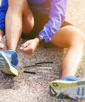 Fix Those Frayed Tips Like A Pro With This 78-Piece Heat Shrink Shoelace End Caps Repair Kit For Sneakers And Casual Shoes Perfect Portable Diy Solution To Restore Your Lace Game Anytime Anywhere Without Breaking The Bank man tying blue sneaker laces with clear and black end caps