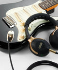 Black guitar with Spark NEO Wireless Guitar Headphone Amp And AI Powered Guitar Rig; includes headphones and cable