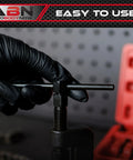 ABN chain breaker tool with T-handle and screw clamp; gloved hand operating the clamp; red storage case in background