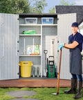 Man standing beside Outdoor Resin Storage Shed With Floor And Metal Shelving Kit 64 Cu Ft Waterproof Vertical Cabinet