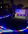 Patriotic Flag Curtain Lights With Stars 6 Ft By 3.5 Ft Outdoor Indoor Waterproof LED String Lights For Fourth Of July Parties 260 LEDs 16 Ft Power Cord UL Safety Low Voltage 110V To 29V displayed on a backyard playset at night
