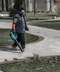 Person operating Top Shelf Brushless Cordless Leaf Blower Featuring Smooth Trigger Cruise Control And Boost Mode on a sidewalk.