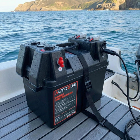 Hardcore 12V Smart Battery Box With Pd Quick Charge Port Anderson Plug Digital Voltmeter Circuit Breaker For Rv Van Suv Overland Grind And Camp Setup on a boat deck with water in background.