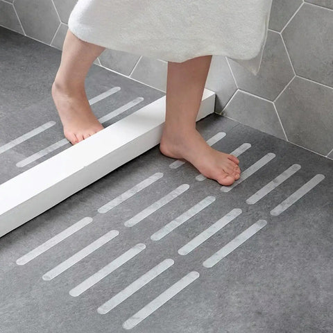 Person stepping on Grippy Non Slip Bathtub And Shower Stickers Set 24 Pieces 8 By 0.8 Inch Anti Skid Treads Tape on bathroom floor