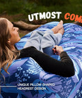 Woman relaxing on an inflatable couch air lounger chair for camping and beach trips with blue foliage design.